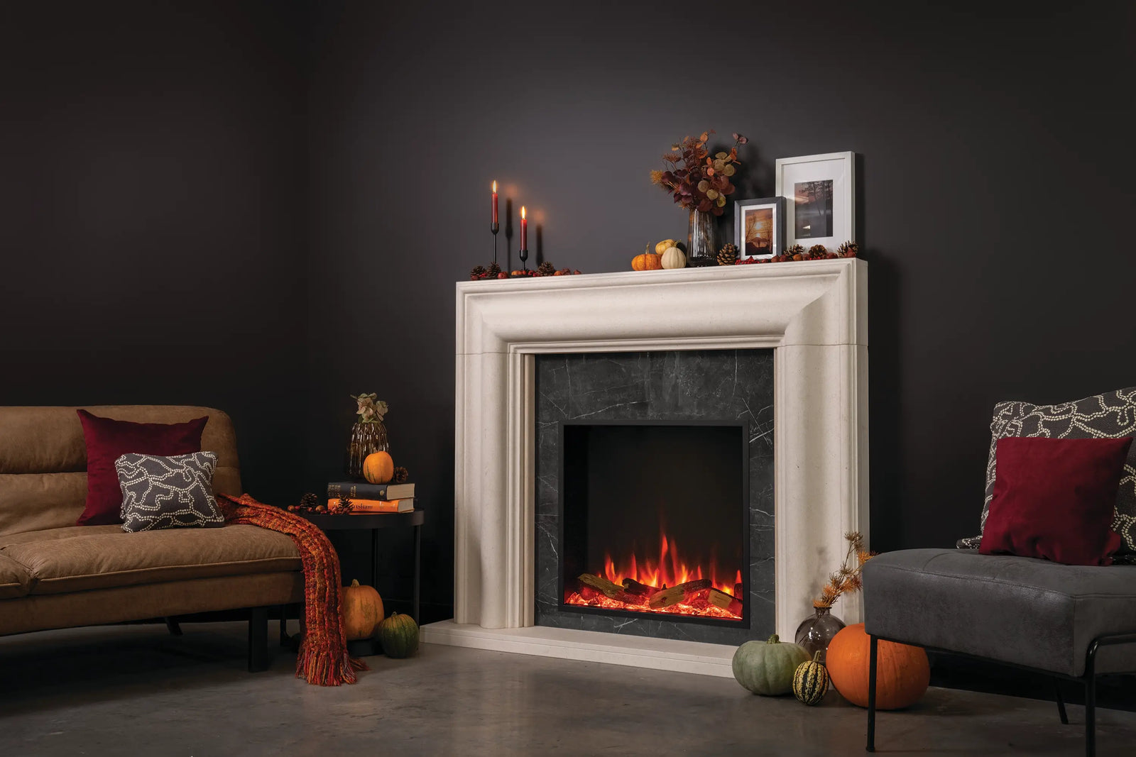 Living room with a fireplace, candles, and decorative pumpkins on a dark background