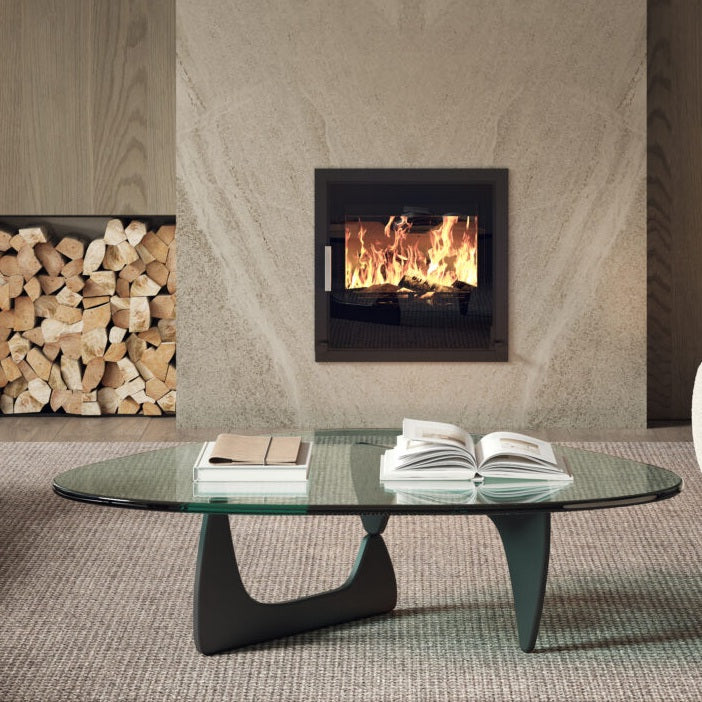 Modern living room with a glass coffee table, books, and a fireplace.