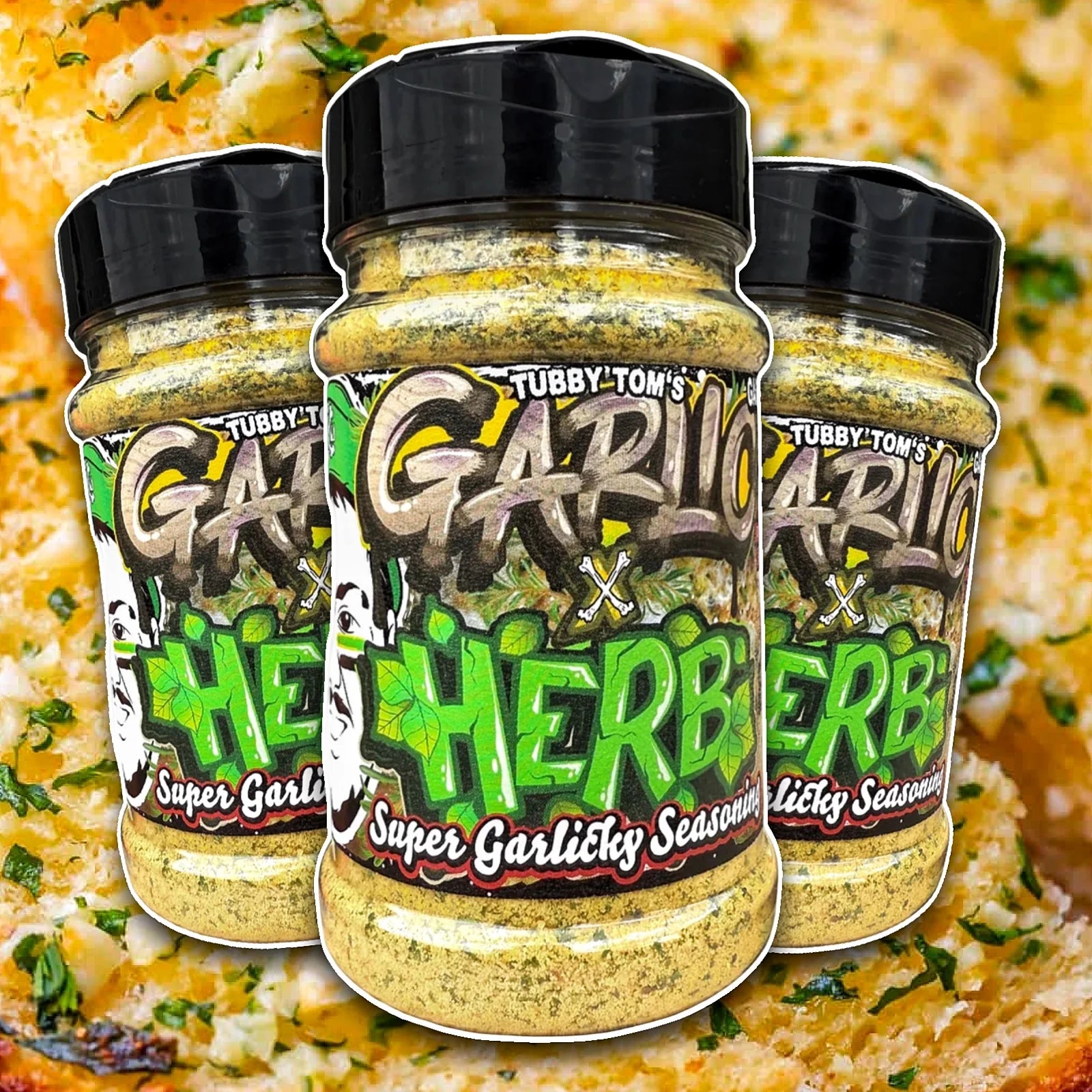 Three jars of Tubby Tom's Garlic x Herb seasoning on a blurred background of a dish.
