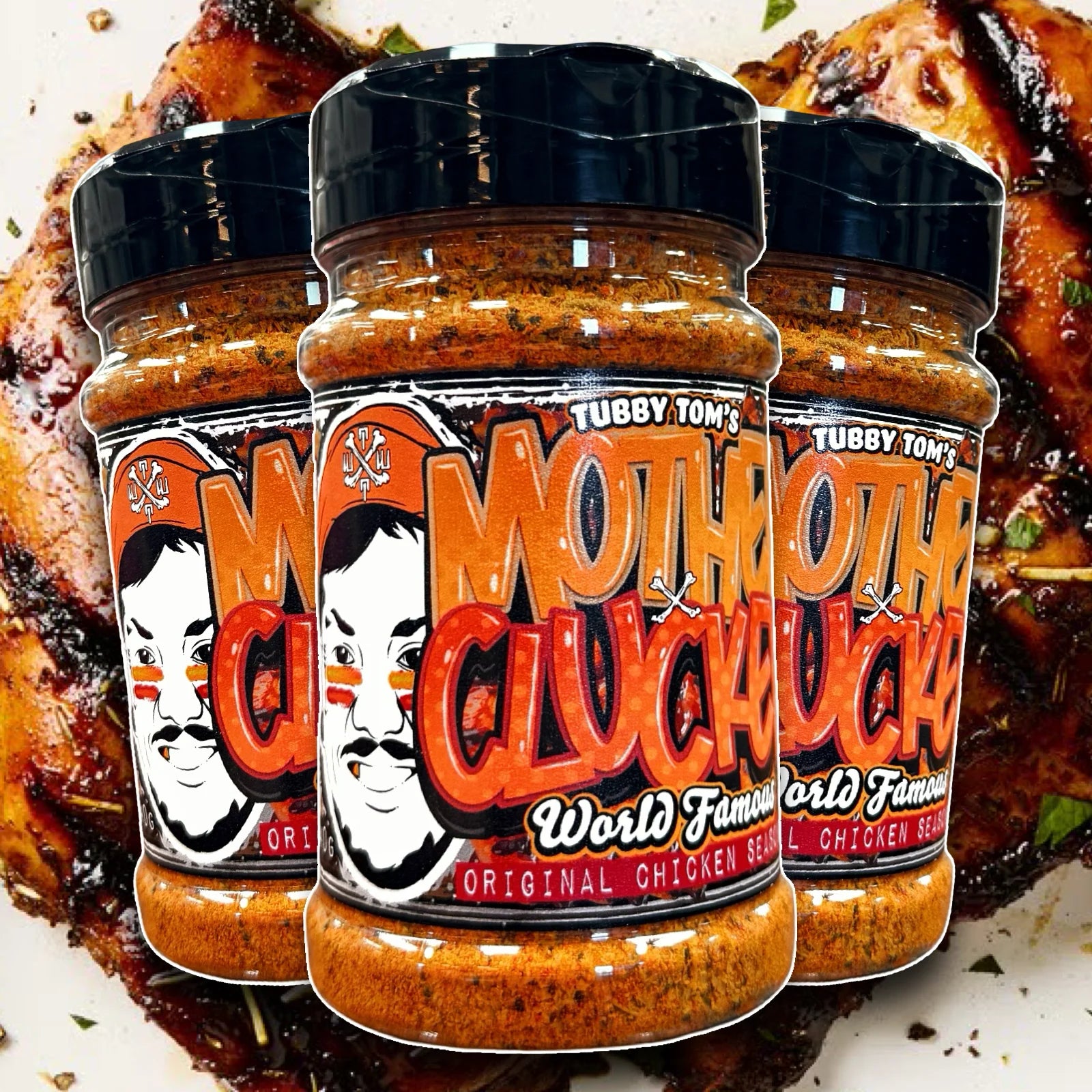 Three jars of Tubby Tom's Mother Clucker World Famous Original Chicken Seasoning on a background of grilled chicken.