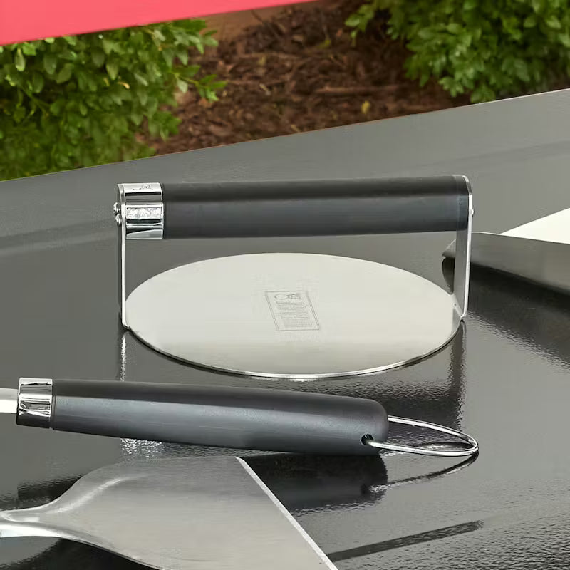 Weber Griddle Smashed Burger Press and other Weber Utensils on a flat surface