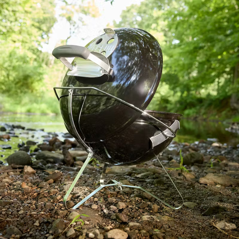 Weber Smokey Joe Charcoal Barbecue 37cm Black on a stand outdoors with greenery in the background