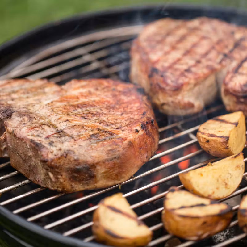 Grilled steaks and potatoes on a Weber Smokey Joe Charcoal Barbecue 37cm Black