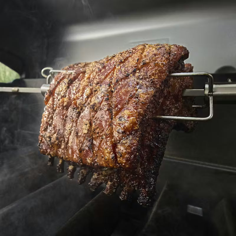 Smoked ribs on a rotisserie over a grill
