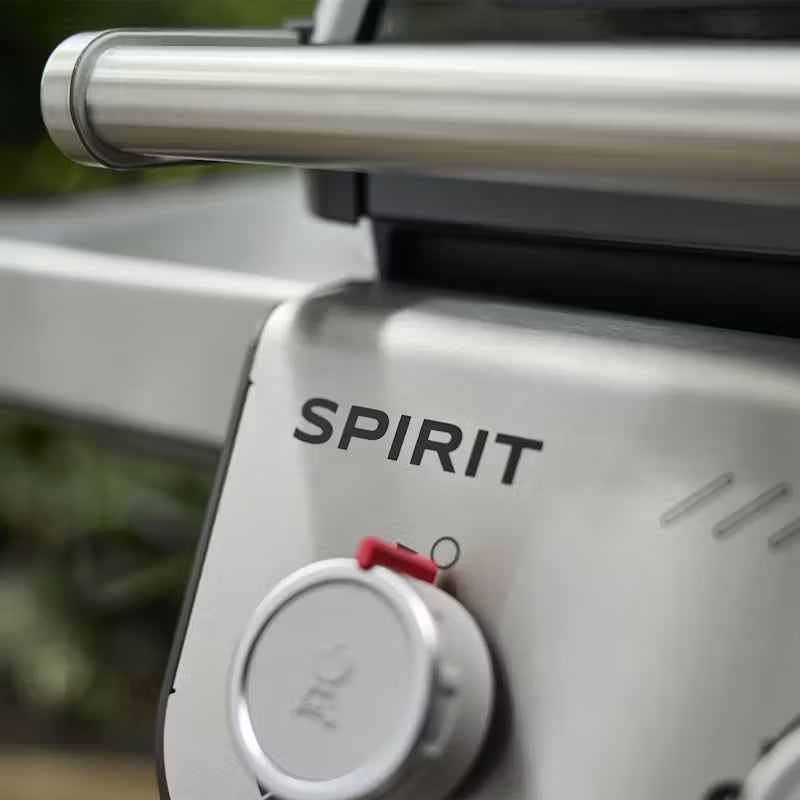 Close-up of a gas grill with 'Spirit' branding on a blurred background