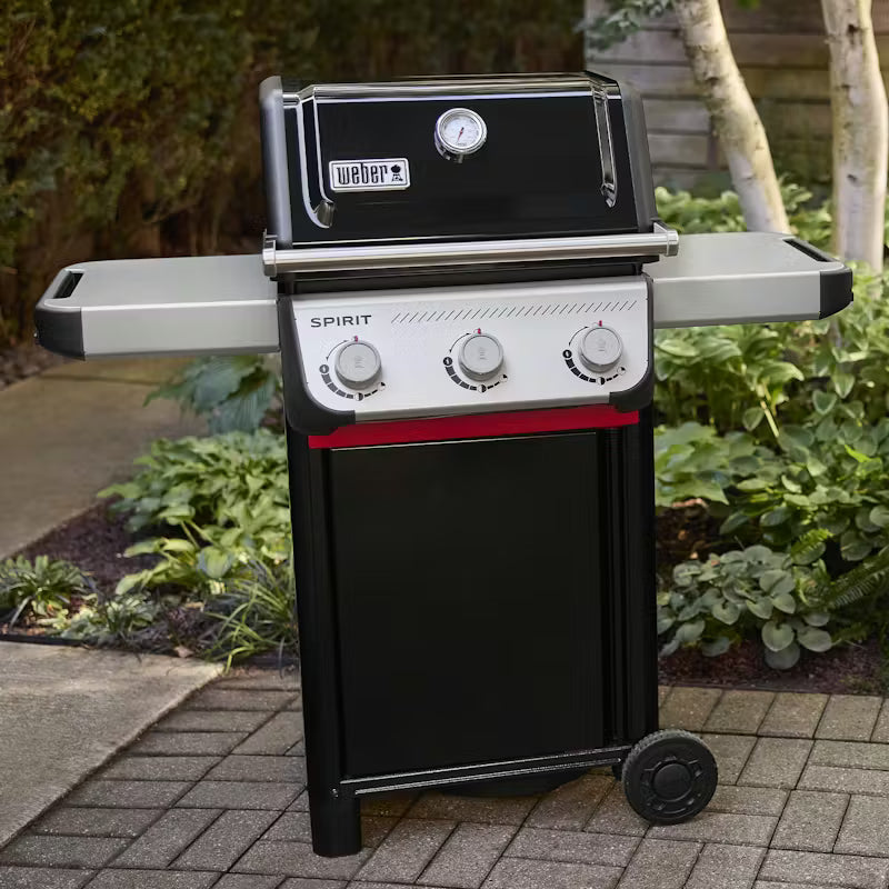 Weber Spirit grill on a patio with greenery in the background